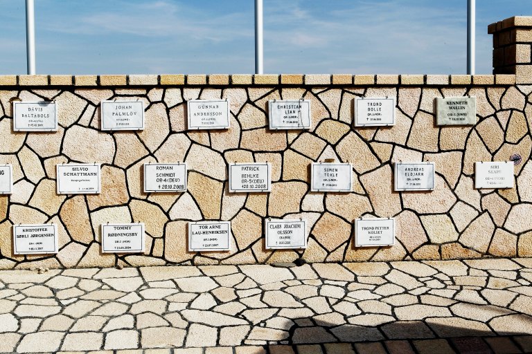 Veggen i minnelunden har plaketter med navnene til de falne.